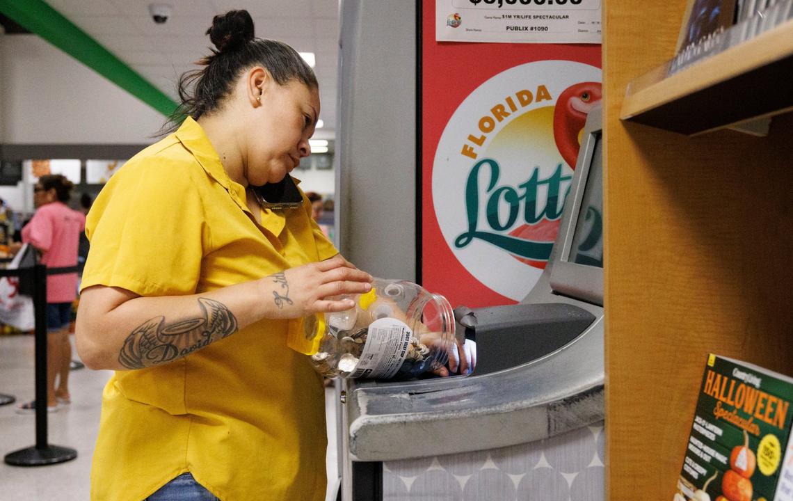 Johanna Villafranca pours $171 worth of coins into the coin counter at a Publix supermarket on Thursday, Oct. 3, 2024, in Miami. Her family is severely cost burdened, spending more than half its monthly income on rent.