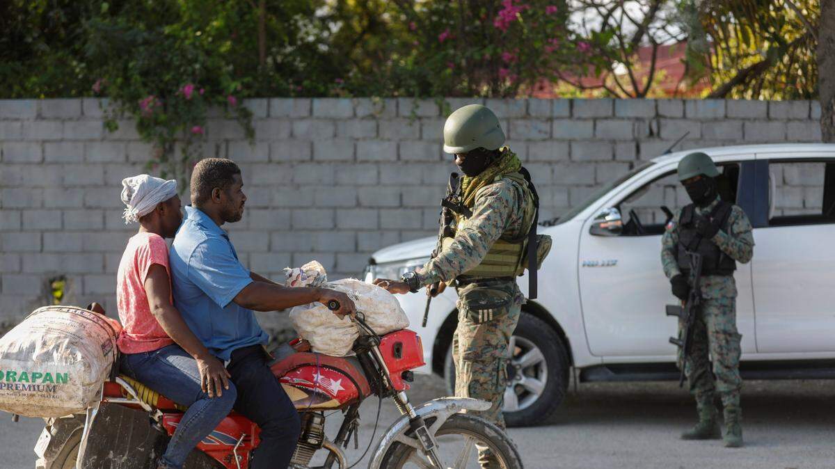 Soldiers inspect commuters at the entrance of the international airport in Port-au-Prince, Haiti, Wednesday, March 6, 2024. (AP Photo/Odelyn Joseph)