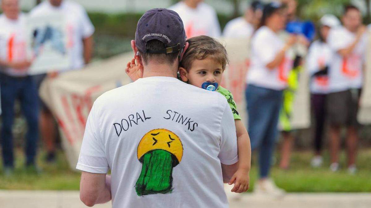 In April, Manuel Rivas carries his son Mateo, as Doral residents protest a new garbage incinerator Miami-Dade County is considering for their city.
