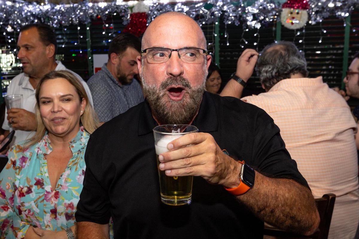 El aparente comisionado electo Damián Pardo reacciona a la noticia de haber desbancado a la titular Sabina Covo durante una fiesta de observación de la segunda vuelta electoral para el escaño del Distrito 2 de Miami en Flanigan's, en Miami, Florida, el martes 21 de noviembre de 2023.