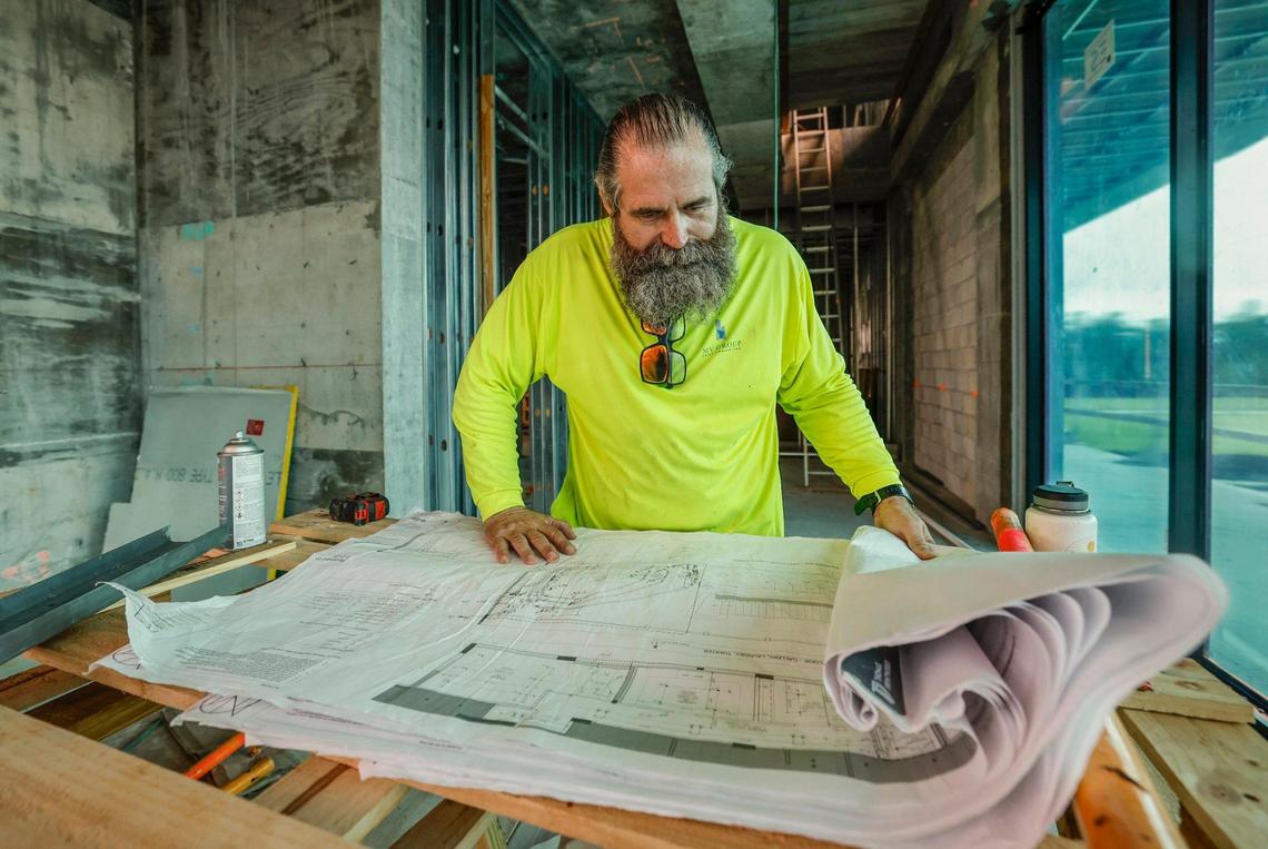 John Varas, brother of developer Manny Angelo Varas, looks over the construction plans for the G House mansion.