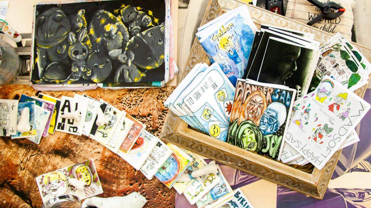 Zines and artwork displayed on a table in 2019.