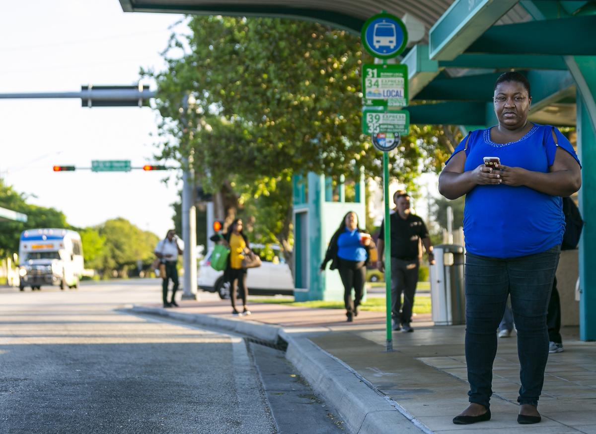 Cameo Parrish, a frequent bus rider, waits at a stop in South Miami Heights near the Southland Mall on Thursday, Nov. 7, 2019. Parrish wants Miami-Dade to preserve stops and routes in South Dade, rather than focus on increasing arrivals at more popular routes elsewhere.