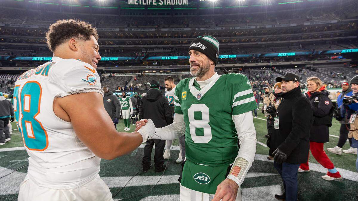 Miami Dolphins defensive end Matt Dickerson (98) shakes hands with New York Jets quarterback Aaron Rodgers (8) after their NFL game at the MetLife Stadium on Sunday, Jan. 5, 2025, in East Rutherford, N.J.
