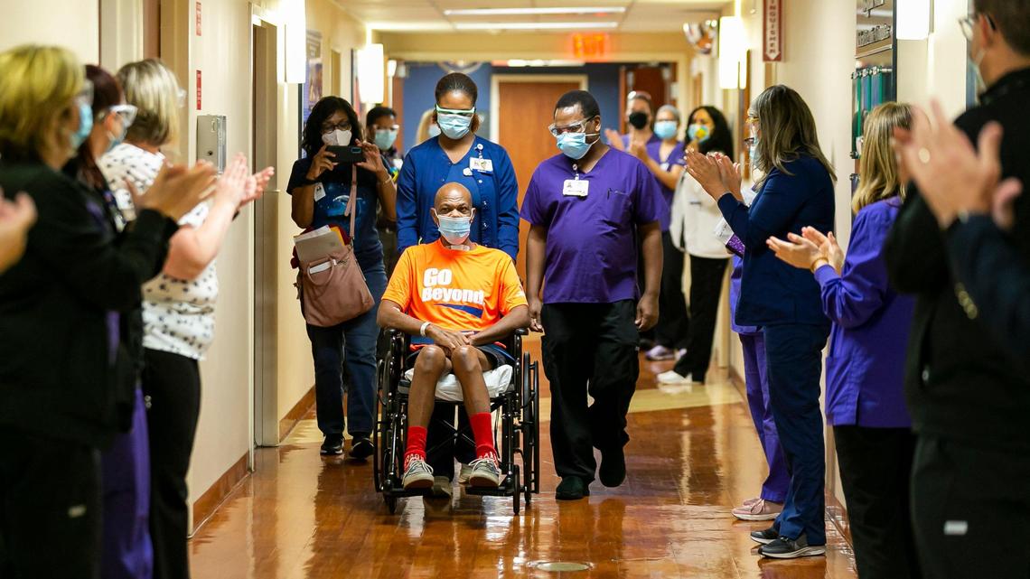 Recovered COVID-19 patient Warren Graham, center, is congratulated after being released from Memorial Regional Hospital South in Hollywood, Florida on Friday, April 16, 2021. Occupational Therapist Samuel Chege, center-right, helped Graham recover during his two month battle with the virus.