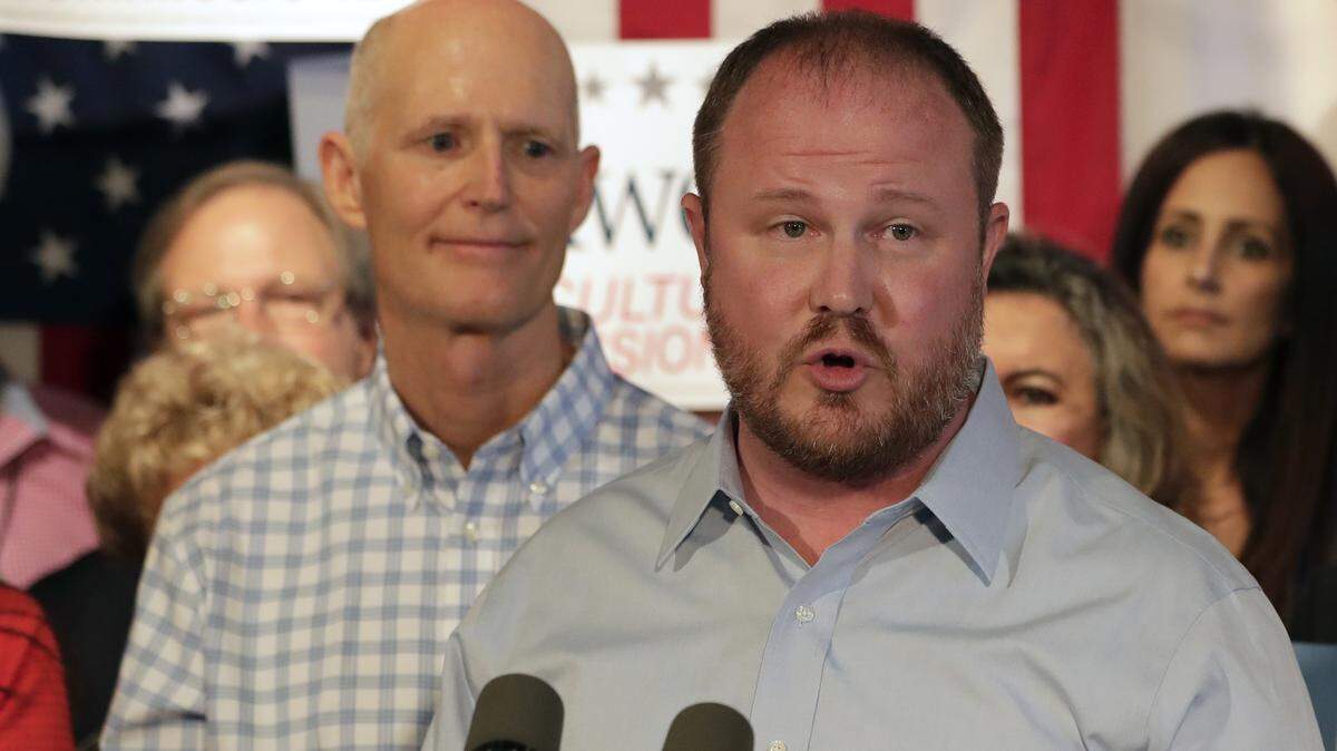 Florida Republican candidate for Commissioner of Agriculture Matt Caldwell speaks as Gov. Rick Scott listens during a rally Sept. 6, 2018, in Orlando.