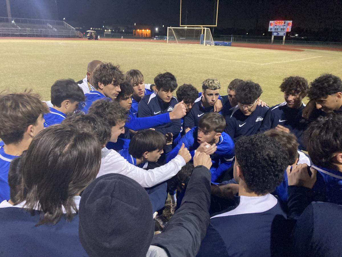 Cypress Bay players huddle up for a pep talk before taking the field against Wellington on Thursday night at Cypress Bay High School.
