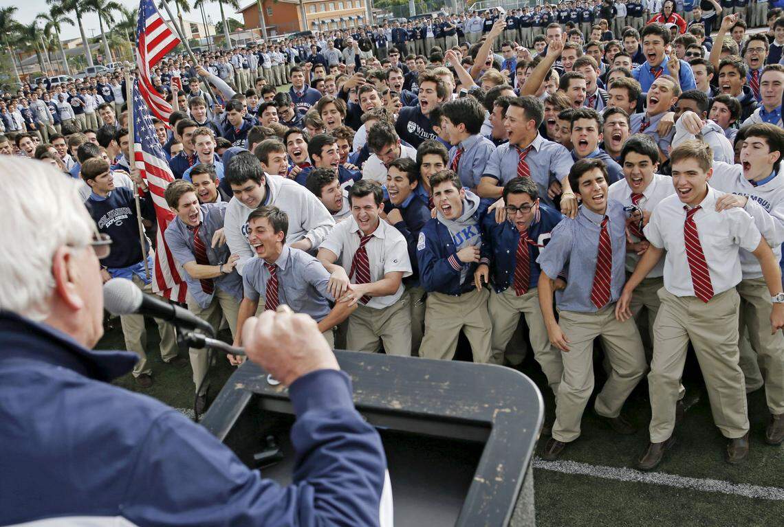 Brother Kevin Handibode, president of Christopher Columbus high school, leads the school in a cheer during a pep rally for the football team before they leave for the state final on Dec. 12, 2014.