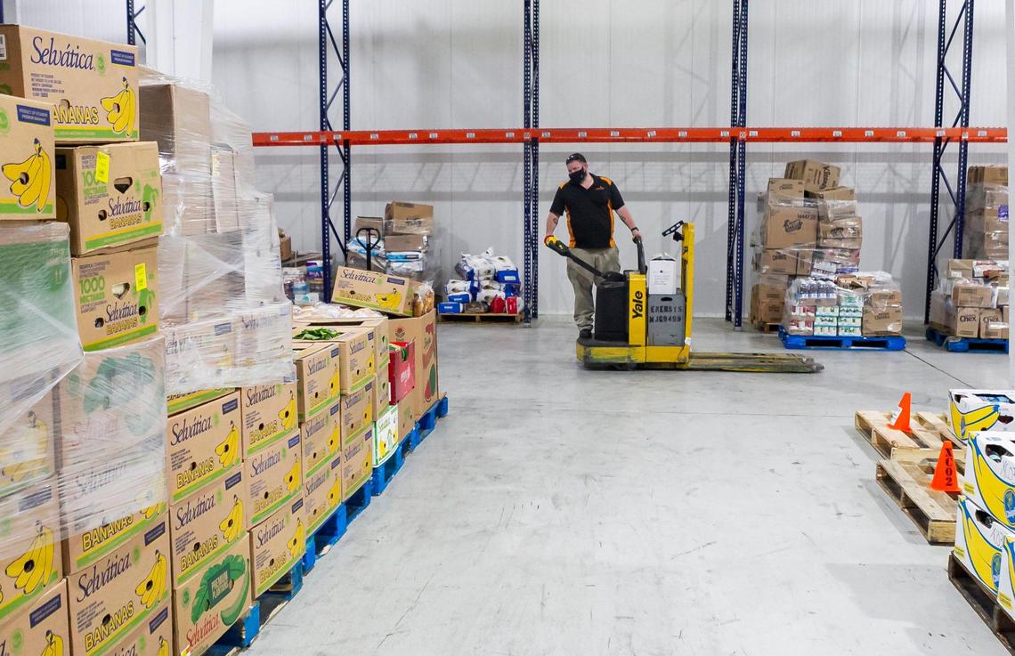 Delmer Swab, 42, a warehouse associate, moves pallets with produce at Feeding South Florida in Boynton Beach, Florida on Wednesday, May 5, 2021.