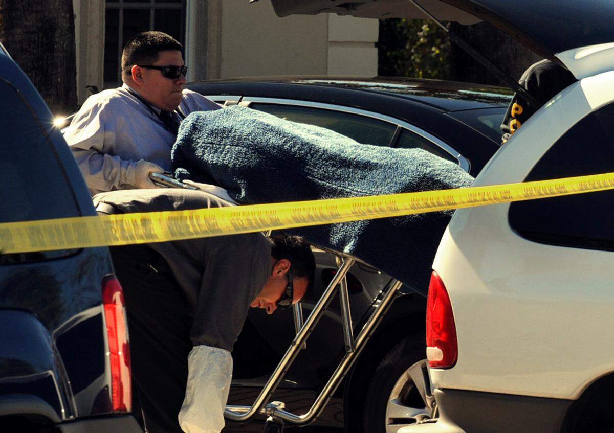 The body of one of the victims killed in a shooting Thursday night, Nov. 26, 2009 is placed in a van at the scene of the incident Friday Nov. 27, 2009 in Jupiter, Fla. Police were searching Friday for a man suspected in the Thanksgiving shooting deaths of his twin sisters, aunt and a 6-year-old cousin during a family celebration.