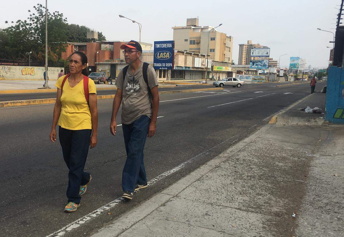 Jessica Martínez walks the streets with her brother-in-law Nerio Paz, who says that people around his slum in the north side of Maracaibo are planning to plunder if power is not restored. (Photo by Gustavo Ocando Alex)