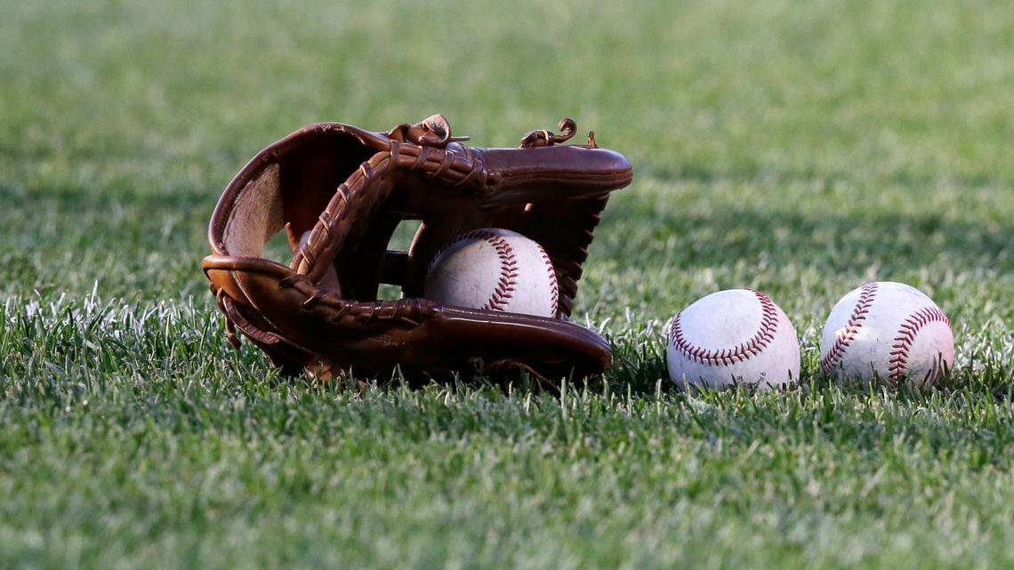 This stock photo shows a glove and baseballs on the grass before the first inning of a baseball game at Fenway Park, Monday, June 20, 2016, in Boston.
