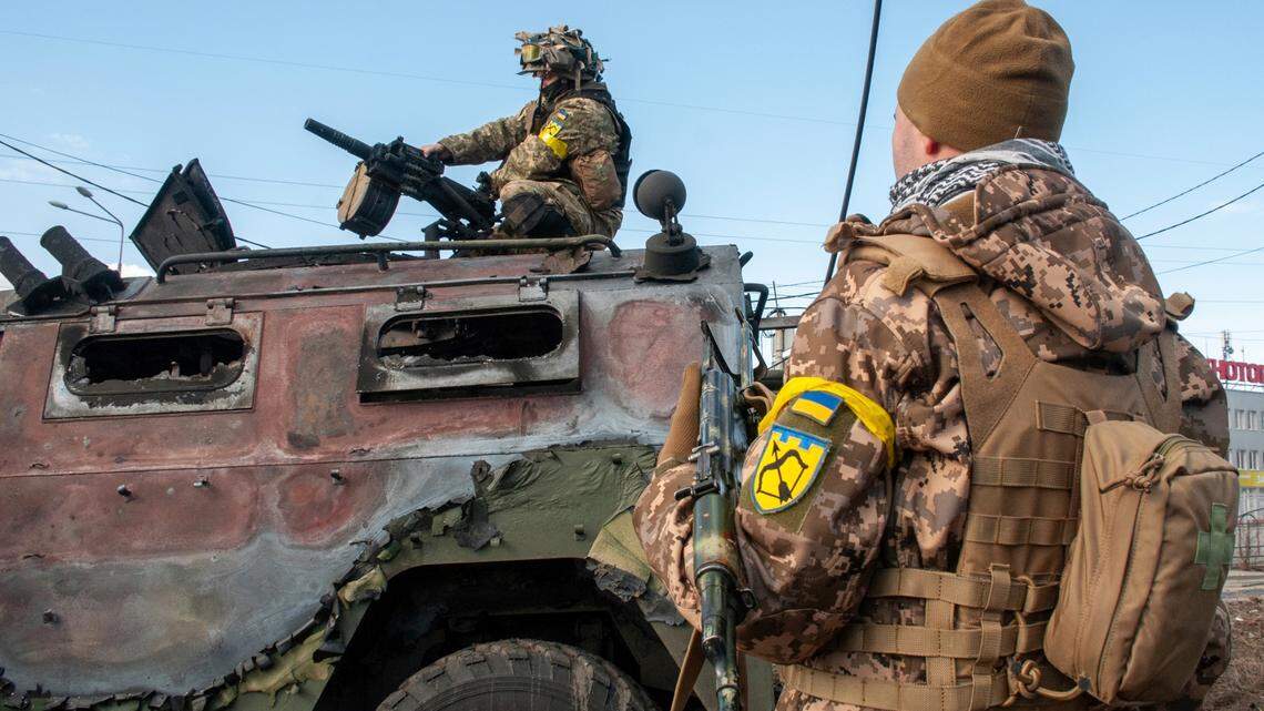 Ukrainian soldiers inspect a damaged military vehicle after fighting in Kharkiv, Ukraine, Sunday, Feb. 27, 2022. Ukraine has called for foreign volunteers to join a new international legion to help fight off Russian forces.