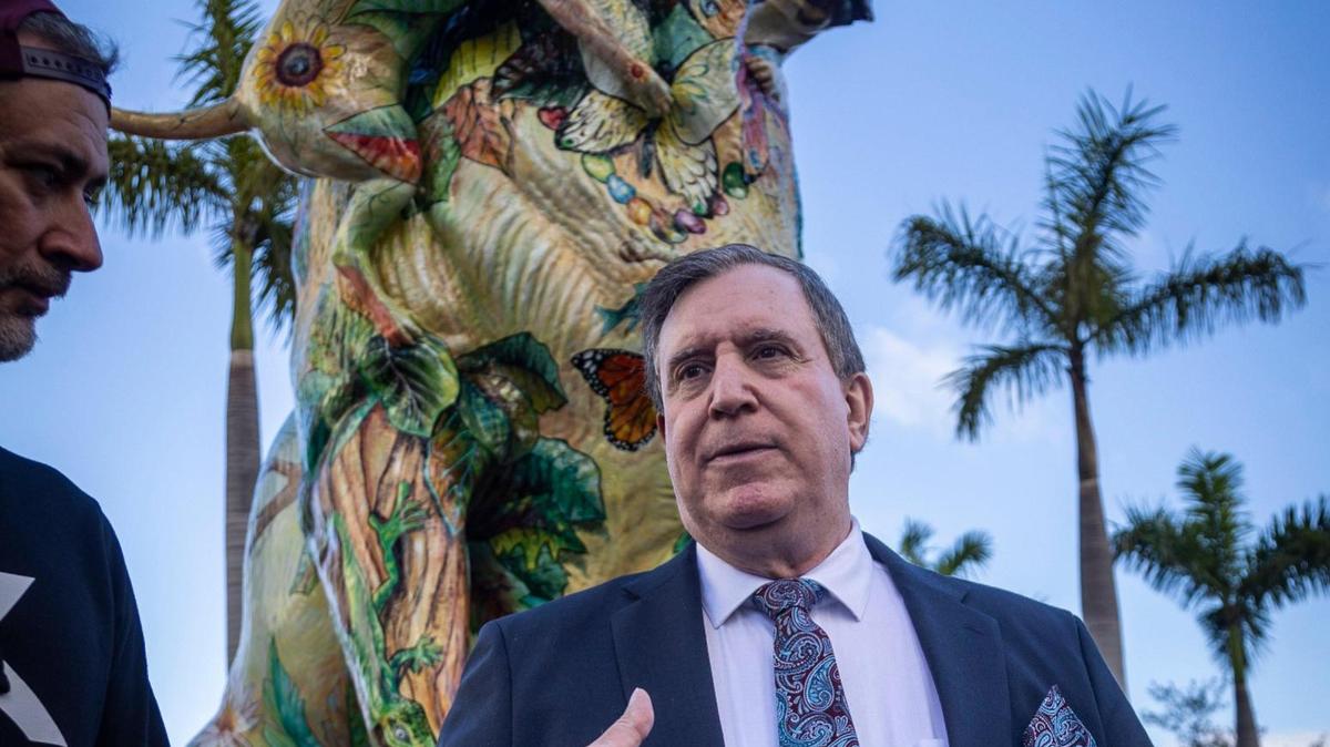 With the statue of a Labrador Retriever called Chócolo in the background, Miami City Commissioner Joe Carollo, center, talks to guests at the ribbon-cutting ceremony for the Dogs and Cats Walkway.