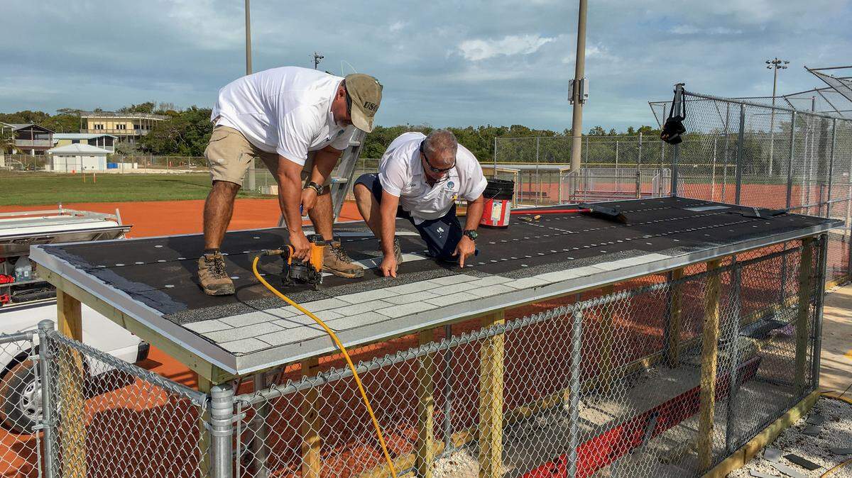 Monroe County Facilities Maintenance workers Karel Alvarez, left, and Julio Mollineda install a new dugout roof at the Harry Harris Park ball fields that are scheduled to reopen Feb. 1.