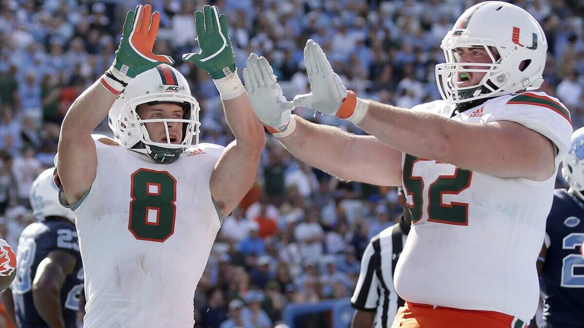 Miami's Braxton Berrios (8) celebrates his touchdown with  KC McDermott (52) during the second half of an NCAA college football game against North Carolina in Chapel Hill, N.C., Oct. 28, 2017. On Friday, the ACC announced UM would play North Carolina at Hard Rock Stadium at 8 p.m.  on Sept. 27.