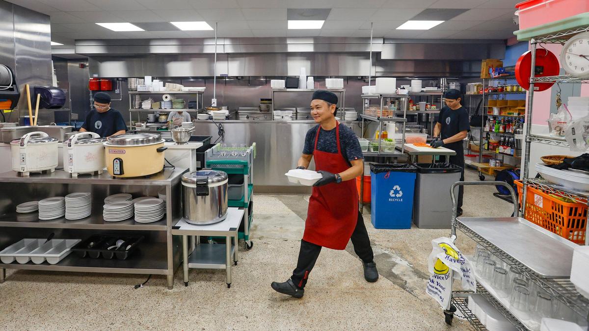 Paiboon Manomai trabajando en la cocina del recién ampliado restaurante Ricky Thai en North Miami, la Florida, el martes 11 de junio de 2024.