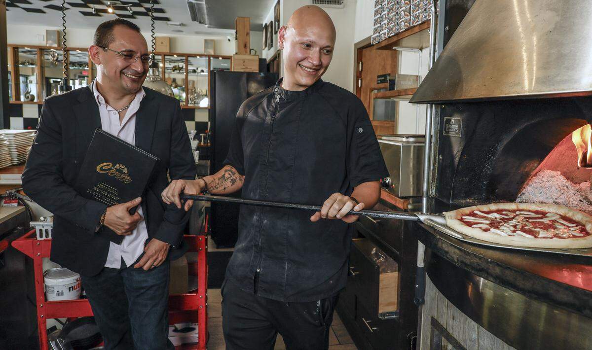 Giovanni Astudillo, owner of the family owned Certo Italian Restaurant, looks over at Pizza Chef Juan Caballero on Thursday, May 14, 2026, in Coral Gables, Florida. 