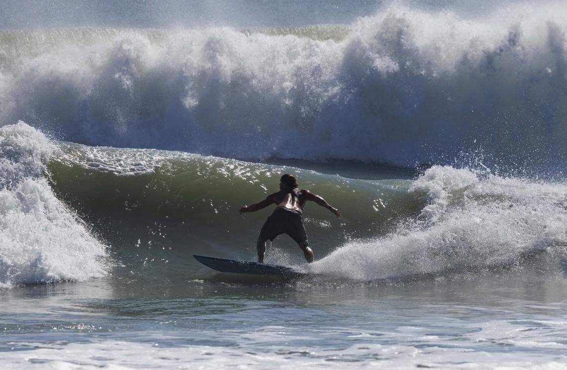 Jonathan Flick catches a wave during the morning on Thursday, Aug. 21, 2025, off the beach in Stuart, Fla. Surfers estimated that waves ranged from 8 - 12 feet all morning.