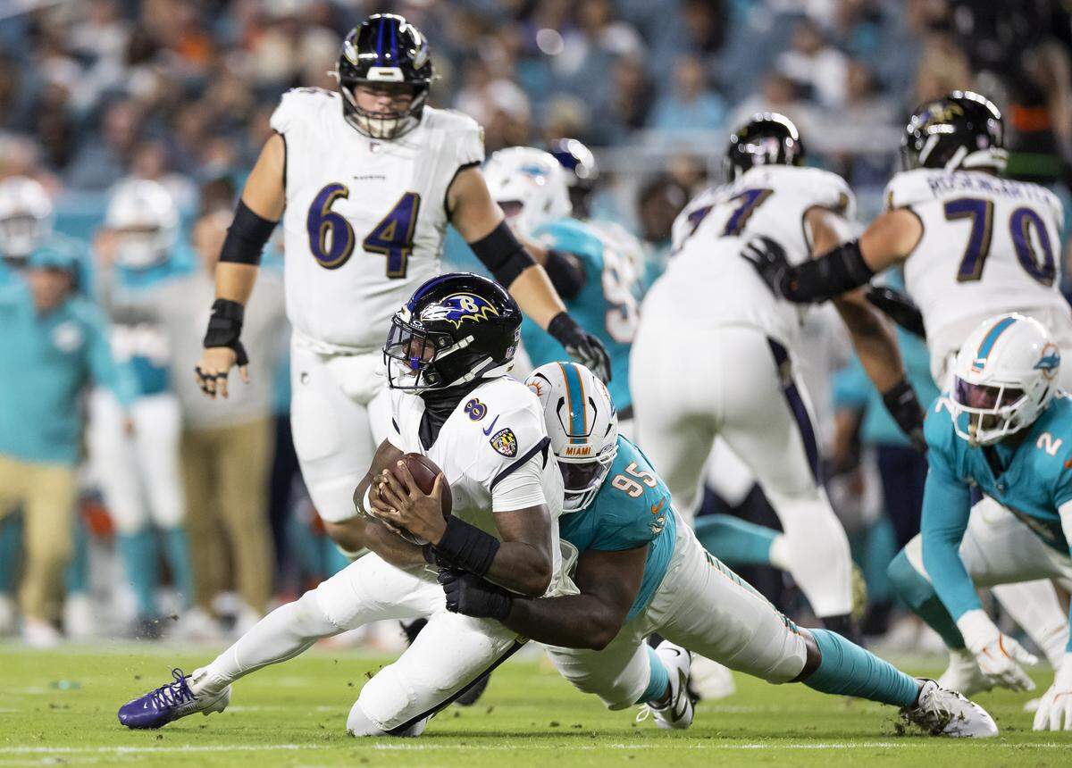 Miami Dolphins defensive tackle Benito Jones (95) sacks Baltimore Ravens quarterback Lamar Jackson (8) in the first half of an NFL game at Hard Rock Stadium on Thursday, Oct. 30, 2025, in Miami Gardens, Fla.