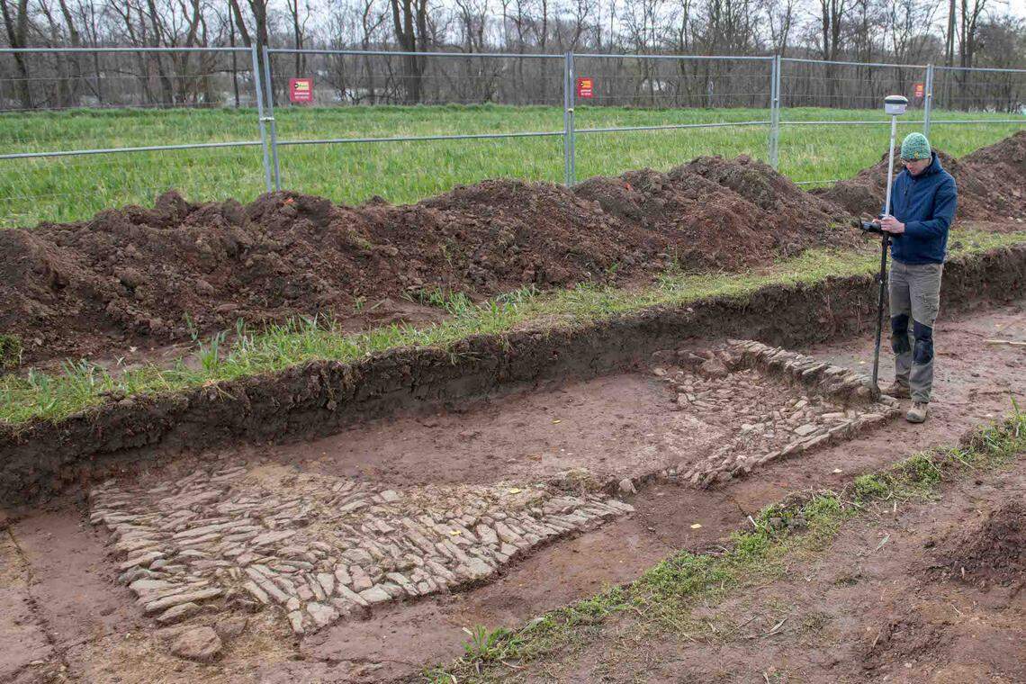 An archaeologist works near the bath house ruins.