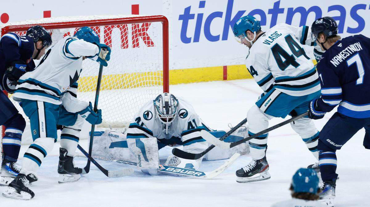 Feb 24, 2025; Winnipeg, Manitoba, CAN; San Jose Sharks goalie Vitek Vanecek (41) smothers the puck as Winnipeg Jets forward Vladislav Namestnikov (7) and Winnipeg Jets forward Cole Perfetti (91) look for a rebound during the third period at Canada Life Centre. Mandatory Credit: Terrence Lee-Imagn Images