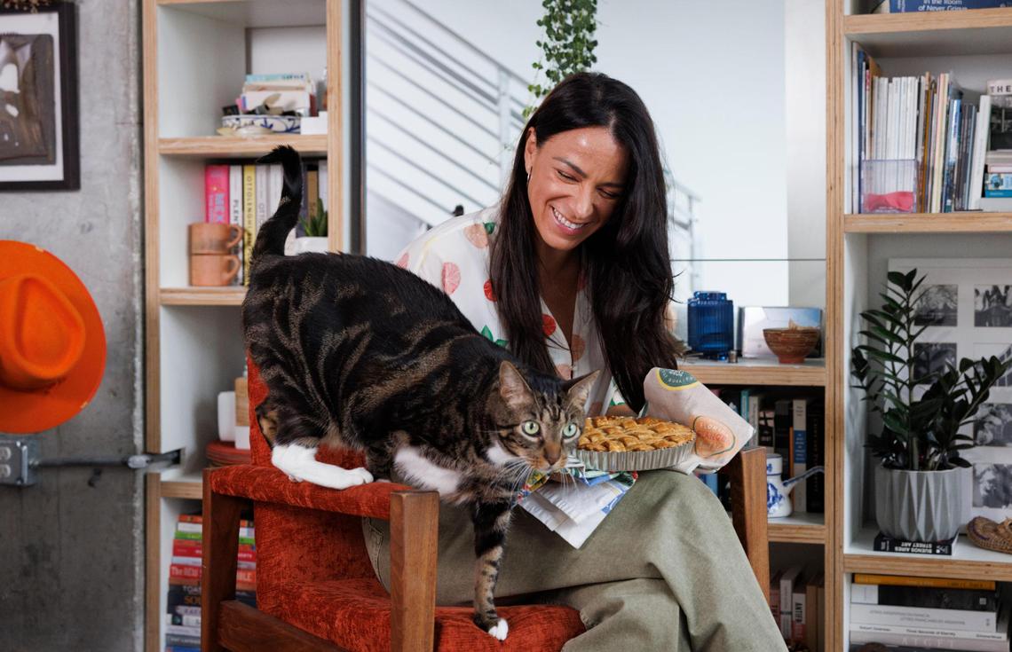 Natalia Martinez-Kalinina poses with one of her mango pies and her cat, Pushkin at her Miami home.