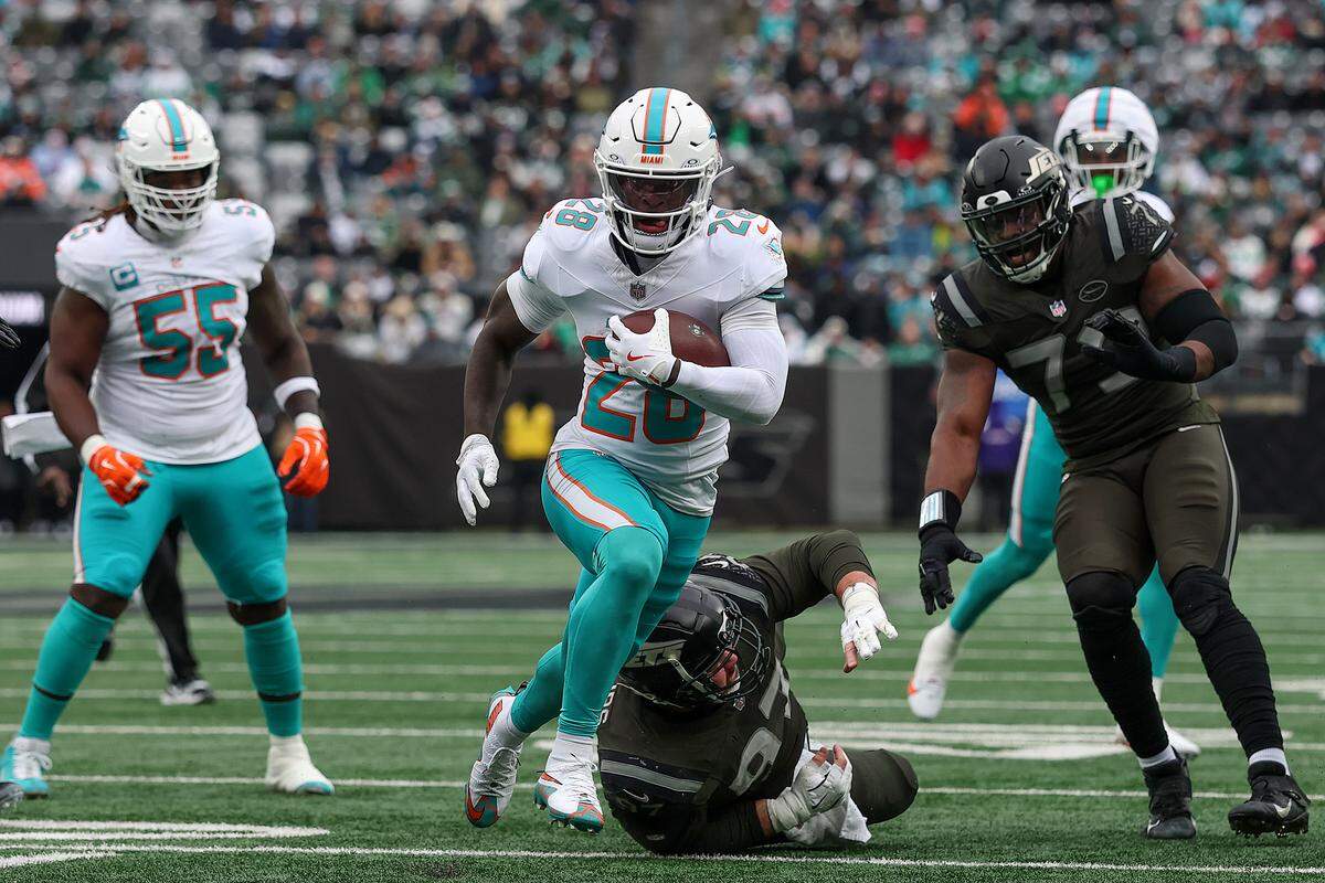EAST RUTHERFORD, NEW JERSEY - DECEMBER 07: De'Von Achane #28 of the Miami Dolphins carries the ball for a touchdown against the New York Jets during the first quarter at MetLife Stadium on December 07, 2025 in East Rutherford, New Jersey. (Photo by Kenneth Richmond/Getty Images)