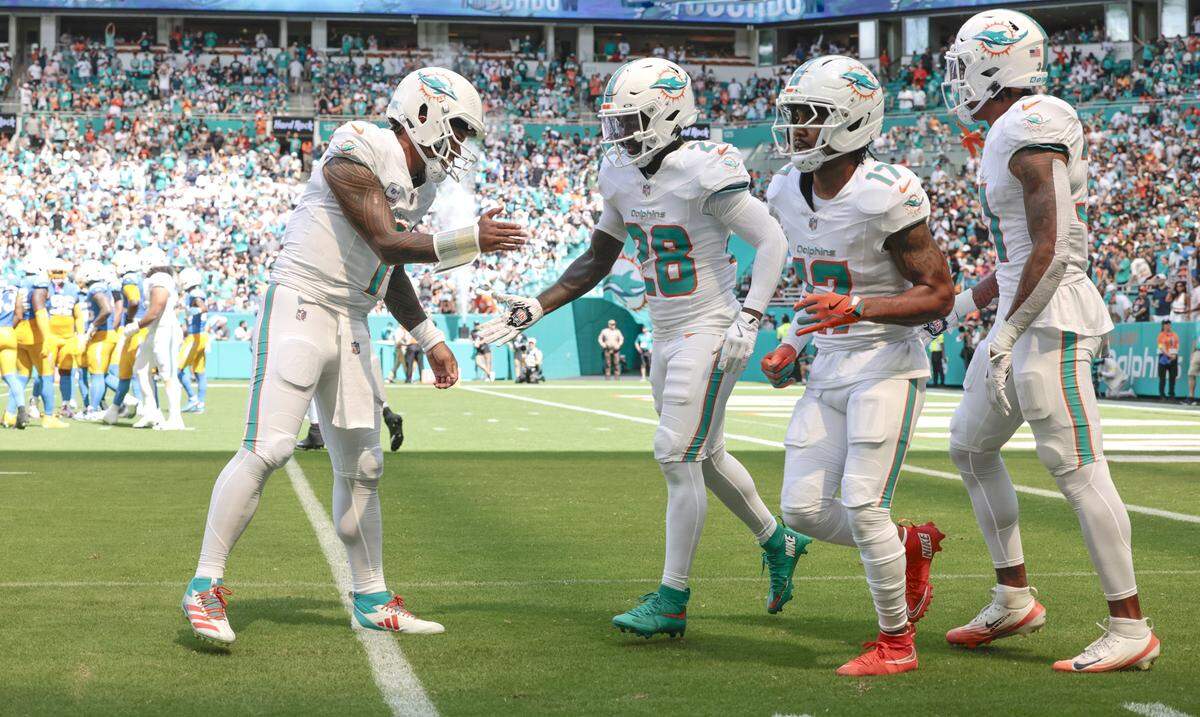 Miami Dolphins quarterback Tua Tagovailoa (1) celebrates with running back De'Von Achane (28) after Achane's touchdown in the first half against the Los Angeles Chargers during their NFL football game at Hard Rock Stadium in Miami Gardens, FL, on Sunday, October 12, 2025. 