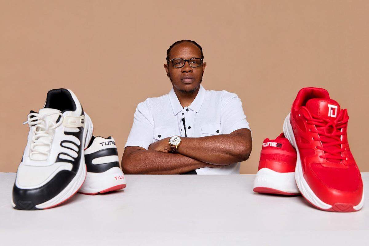 Tunez Footwear founder Michael Stover shows off two of his company’s sneakers.