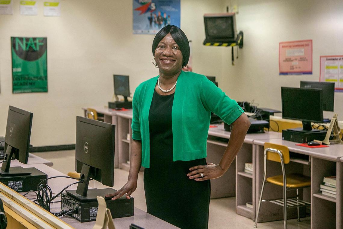 Miami-Dade Schools Teacher of the Year Finalist, Central Region winner, Yolette Mezadieu. She is standing by the second-row seat in her classroom at Miami Edison Senior High, where she used to sit when she was a student there, Tuesday, Jan. 26, 2021.