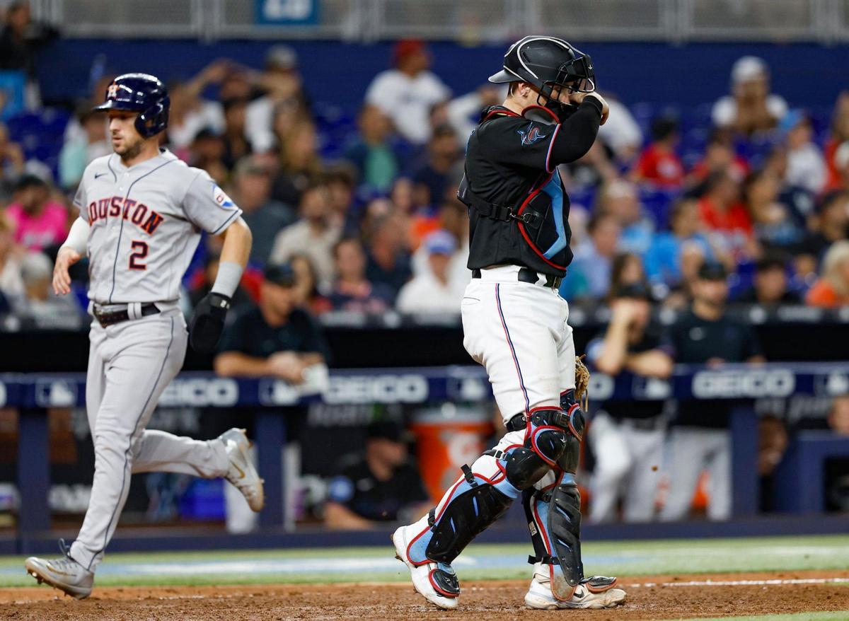 Miami Marlins catcher Nick Fortes (4) reacts as Houston Astros third baseman Alex Bregman (2) scores in the seventh inning at loanDepot park in Miami on Wednesday, August 16, 2023.