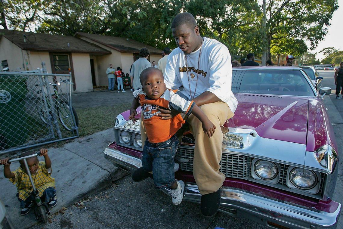 Now-retired NFL great running back Frank Gore plays with his son, Frank Gore Jr., outside his childhood home in the historically Black section of Coconut Grove in 2005 when he played at the University of Miami in 2005. The younger Gore is now a running back at Southern Mississippi.