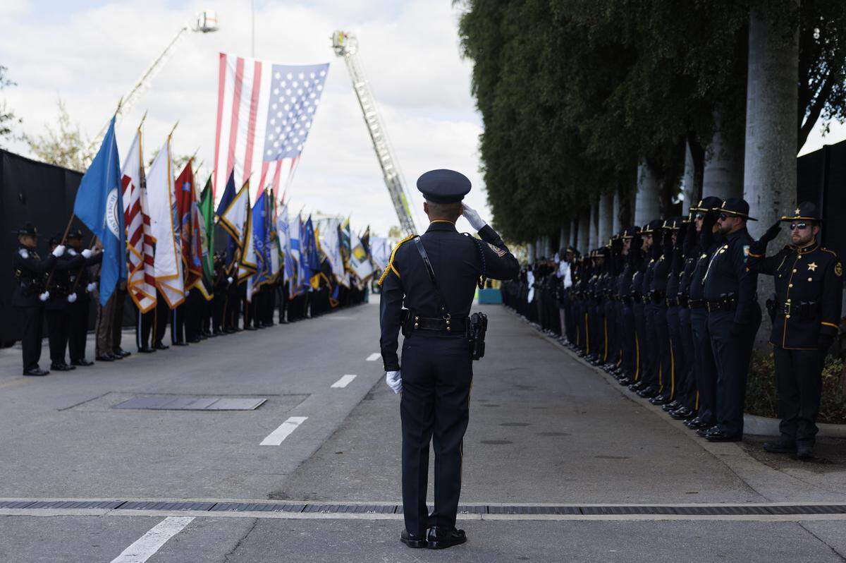 The officer in charge of the Honor Guard calls them to attention for the procession into a funeral service for Miami Beach Police Sergeant David Cajuso on Wednesday, Nov. 12, 2025, at the Hard Rock Stadium in Miami Gardens, Fla.