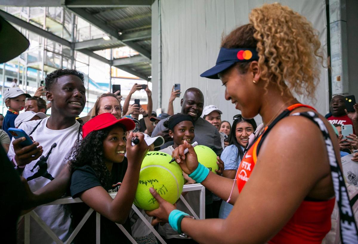 Naomi Osaka, of Japan, signs autographs after her match against Alison Riske, of U.S., at the Miami Open tennis tournament on Monday, March 28, 2022 at Hard Rock Stadium in Miami Gardens, Florida.
