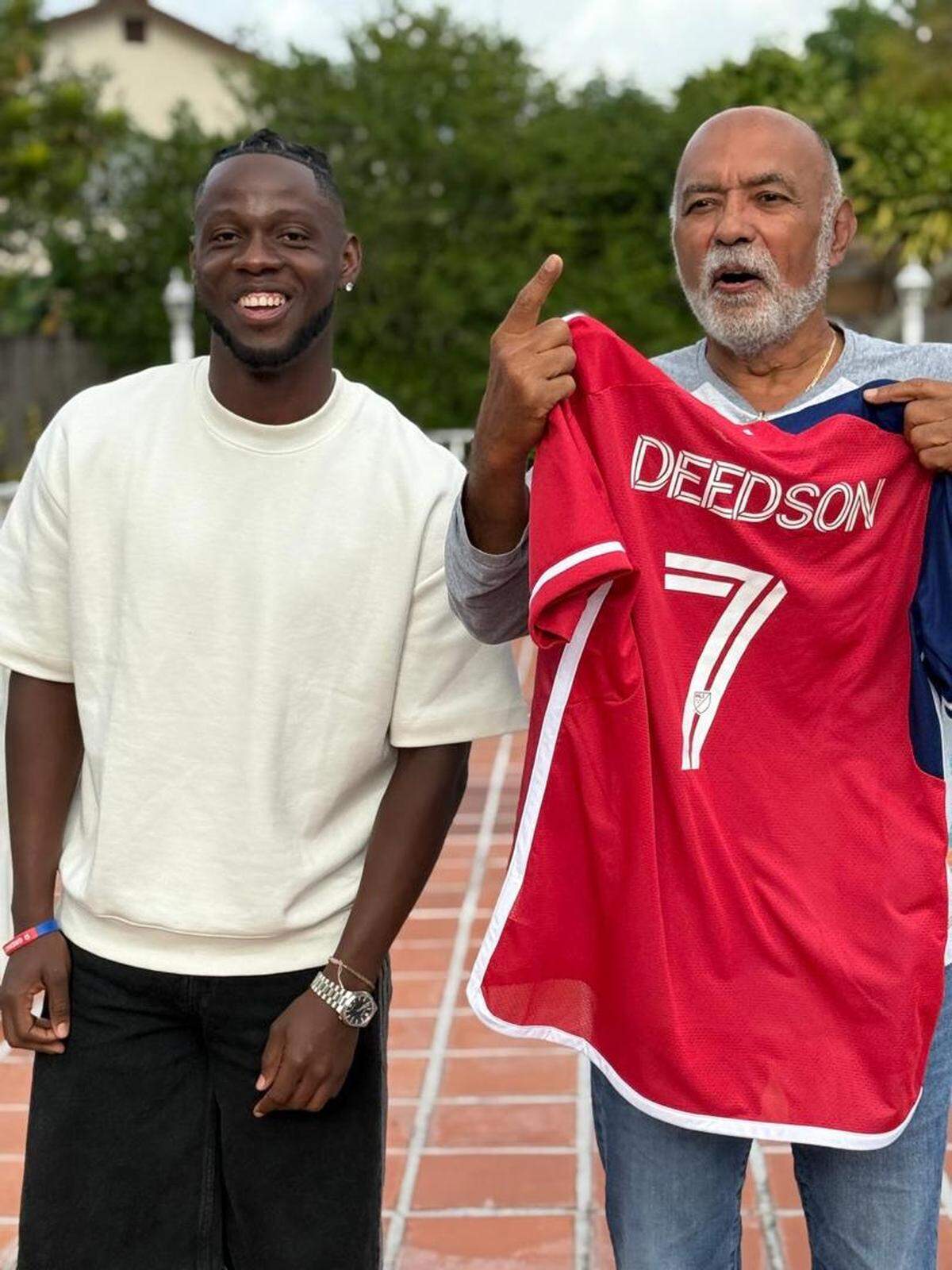 Don Deedson Louicius, left, a forward who was named to Haiti’s men’s national soccer team squad, poses with Patrice Millet, who runs the soccer academy in Haiti where Louicius and a fellow squad member, midfielder Leverton Pierre, played before going professional.
