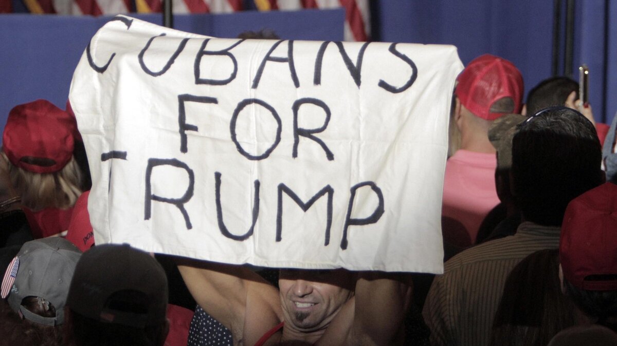 UN PARTIDARIO CUBANO de Donald Trump sostienen un cartel casero antes del inicio de la manifestación “Latinos por Trump” en Miami.