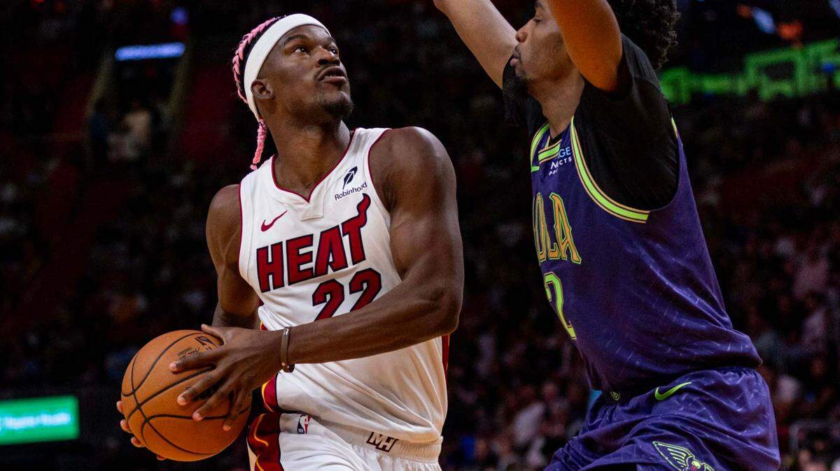 Miami Heat forward Jimmy Butler (22) dribbles into the paint while defended by New Orleans Pelicans forward Herbert Jones (2) during the second half of an NBA game at Kaseya Center on January 1, 2025, in Miami.