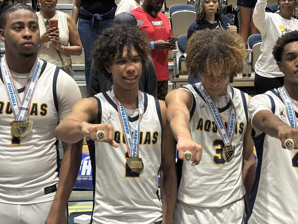 St. Thomas Aquinas boys’ basketball players and siblings, DJ and KJ Sandi, show off their state championship rings following their win over Orlando Evans in the Class 6A state final on Saturday at UNF Arena in Jacksonville, Fla.