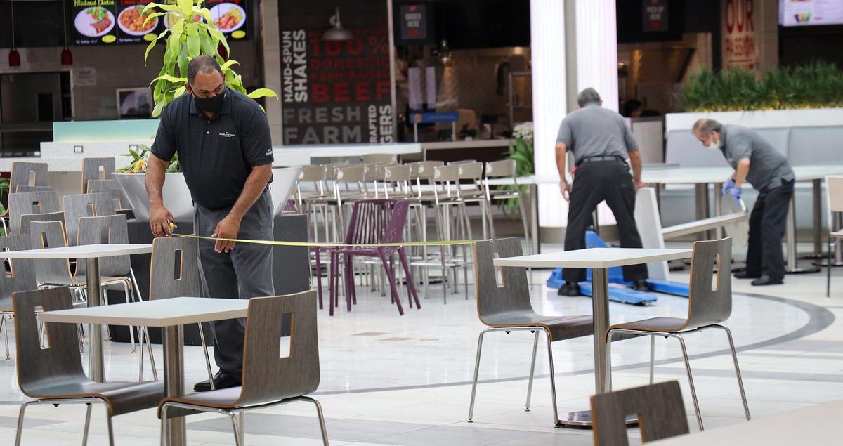 Workers remove and space out chairs at Dadeland Mall on Monday, May 18, 2020.