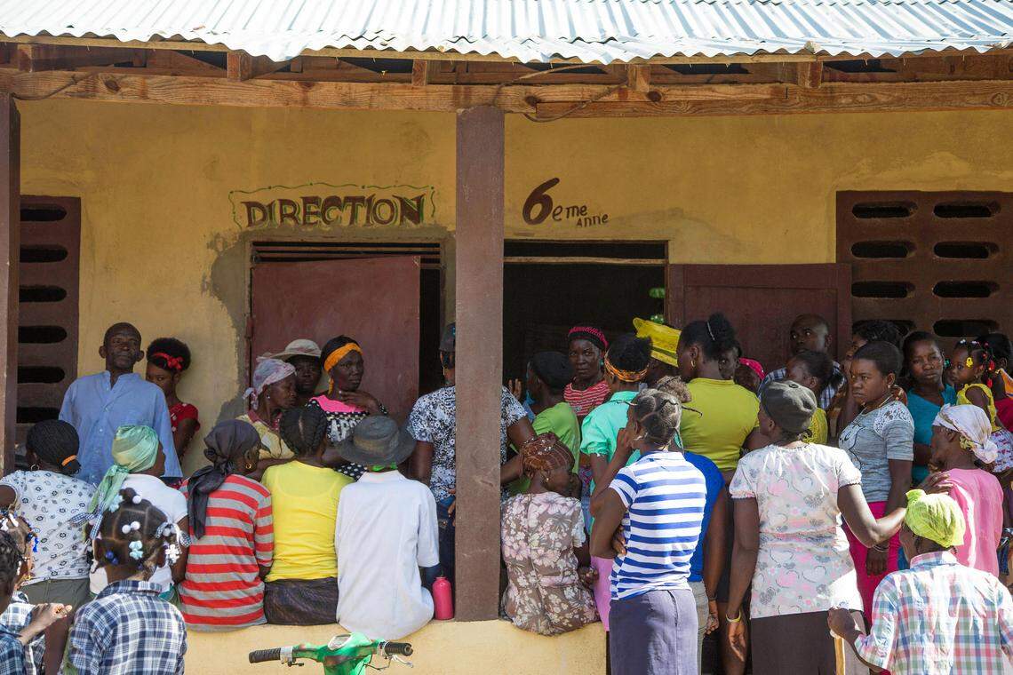 Haitian women wait for hours outside a school in Pignon, Haiti, for cervical cancer screening and treatment by doctors with Primary Care Haiti.  The Broward-based nonprofit also trains Haitian healthcare providers how to screen for the cancer.