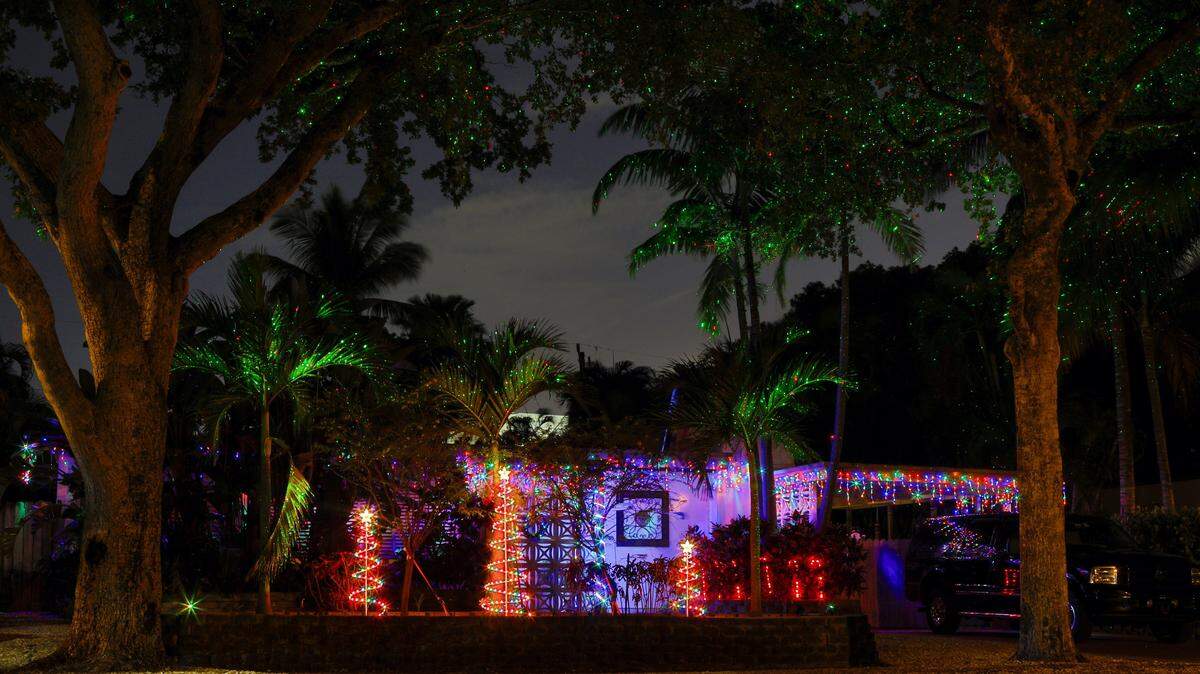 Una casa de North Miami, con árboles de Navidad de diferentes tamaños, un espectáculo de luces láser y otras decoraciones.