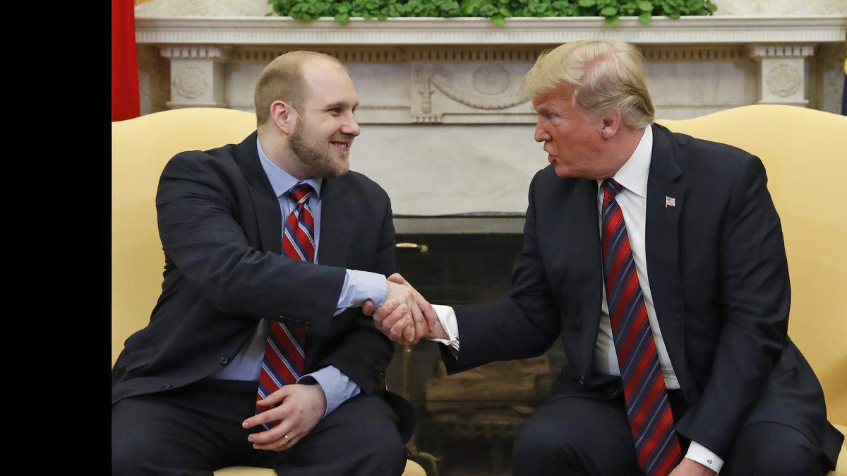 President Donald Trump shakes hands with Joshua Holt, who was recently released from a prison in Venezuela, in the Oval Office of the White House, Saturday, May 26, 2018, in Washington. (AP Photo/Alex Brandon)