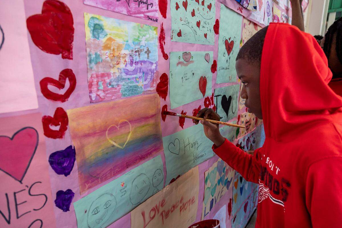 A student at Silver Lakes Middle School paints hearts on the mural at a ceremony Tuesday, Feb. 14, in memory of those killed at Marjory Stoneman Douglas High School five years ago.