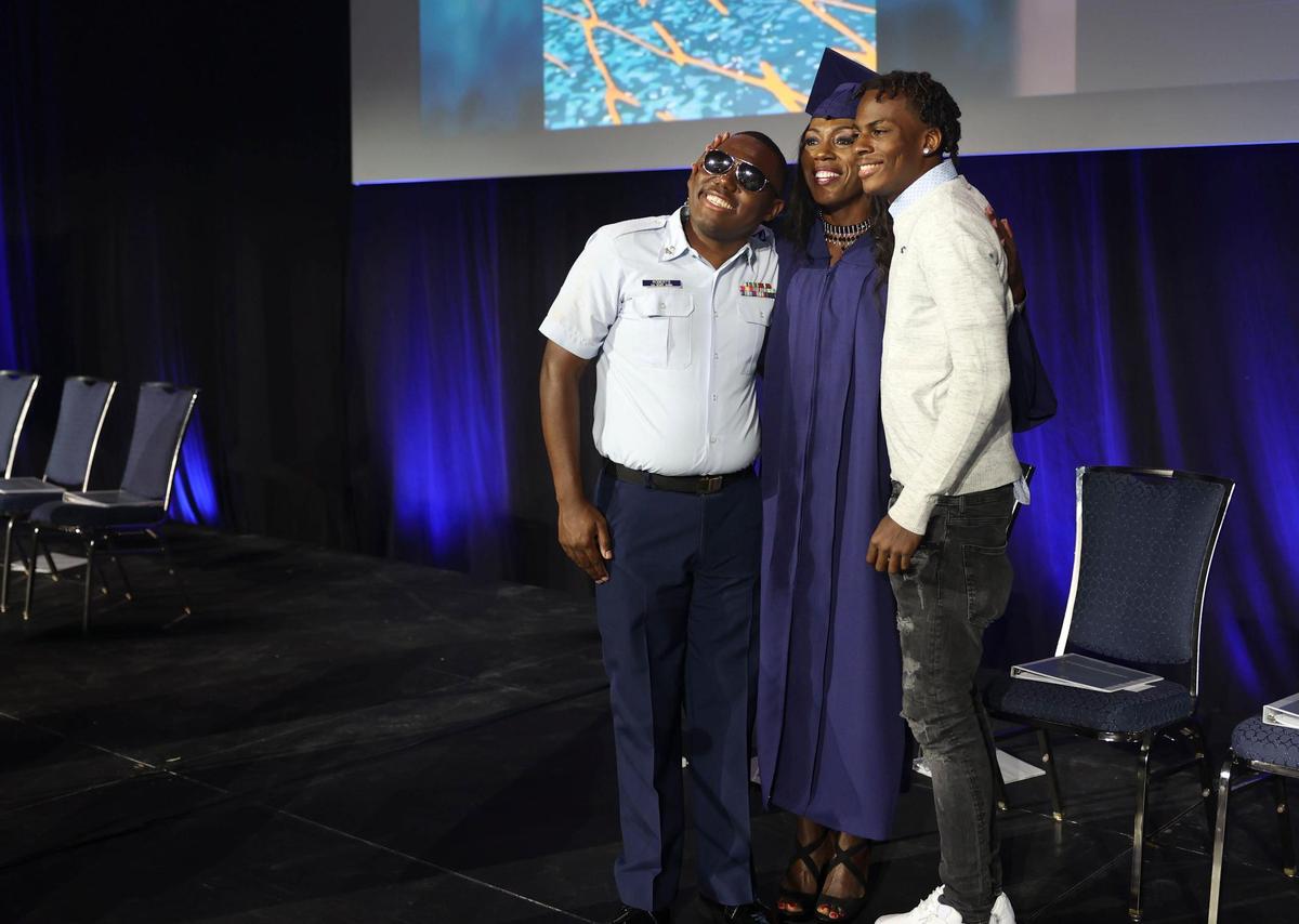 Marcus Roberts, U.S. Coast Guardsman, left, his mother, Jennifer Freeman, center, and his cousin, Trovex Bain, after Roberts surprised Freeman, 54, before her graduation from Broward College at the Broward County Convention Center in Fort Lauderdale on Thursday, May 5, 2022. Freeman helped raise Bain as well. “Both of them are my boys,” said Freeman.