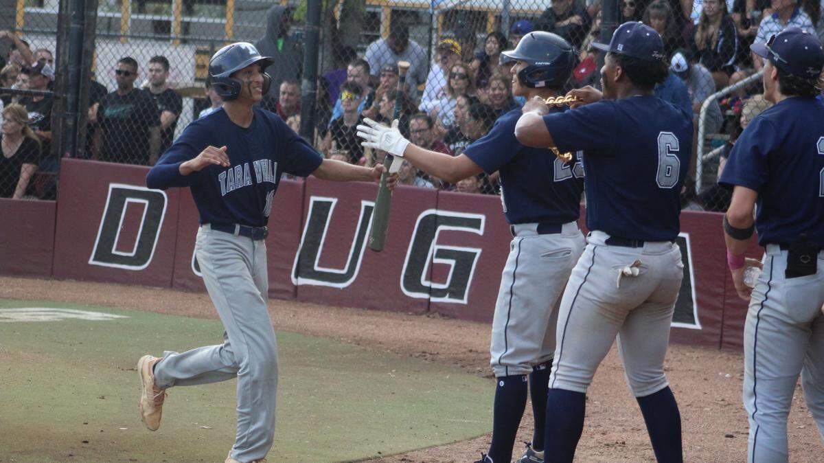 Javi Miranda is greeted by his Taravella teammates after scoring a first inning run during the Trojans’ 3-2 loss to Douglas in a Region 4-7A baseball semifinal on Friday.