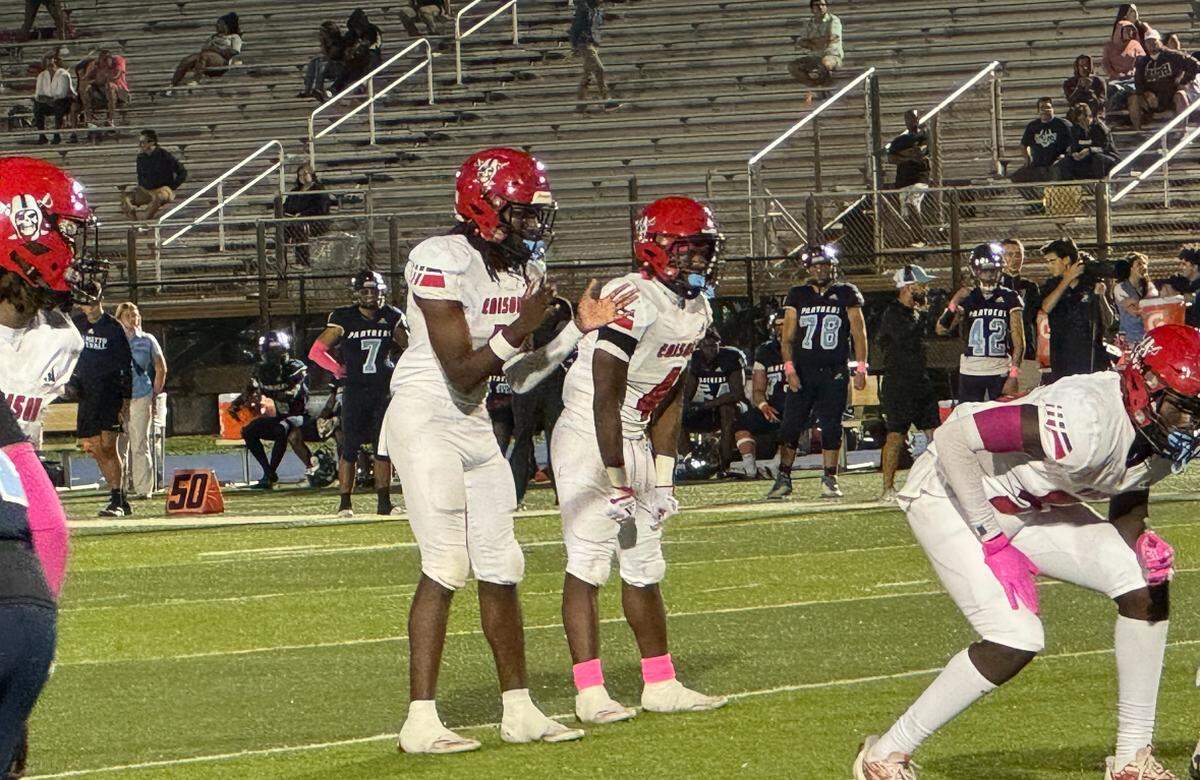 Miami Edison quarterback Emmanuel Poitier and running back Sterling Joseph prepare to run a play during their game on Thursday night against Miami Palmetto at Tropical Park in Miami, Fla.