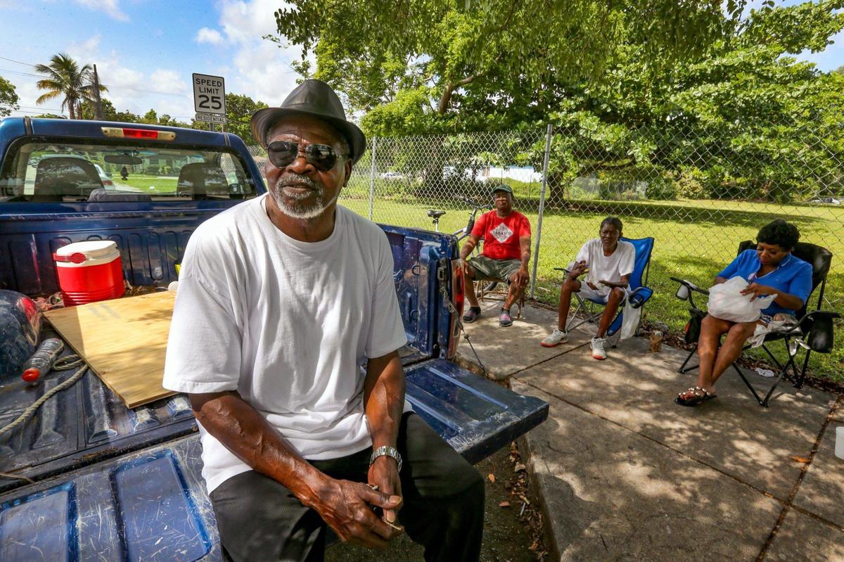 Calvin Williams, a retired restaurant cook and lifelong resident of Miami’s historically Black West Coconut Grove, sits on the back of his truck while chatting with friends outside a convenience story on Grand Avenue and Plaza Street on Wednesday, June 15, 2022.