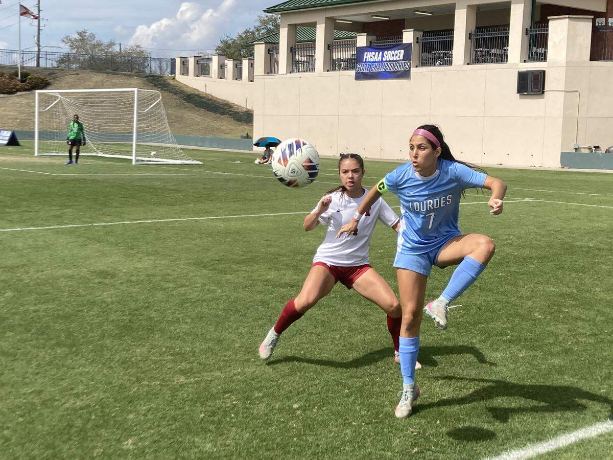 Lourdes’ Lorena Alvarez, who scored a pair of goals, duels Innovation defender during Friday’s Class 5A state girls’ soccer semifinal at Spec Martin Stadium in DeLand, Fla.