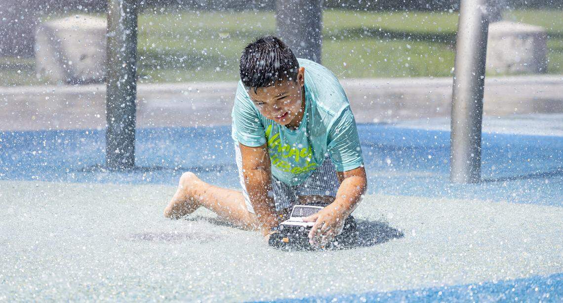 Mateo Tuesta, 7, plays with a toy at the splash pad in South Pointe Park as hot weather moves through the area on Friday, Aug. 15, 2025, in Miami Beach, Fla. Forecasters have issued heat advisories throughout the summer in South Florida, with temperatures at times feeling as hot as 109 degrees.